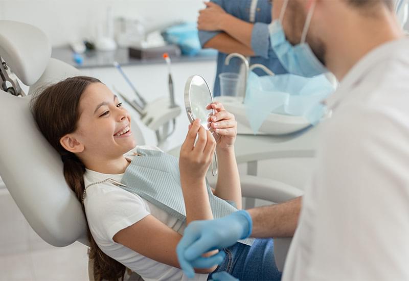 Central Dental Family - Dentist showing their patient their teeth